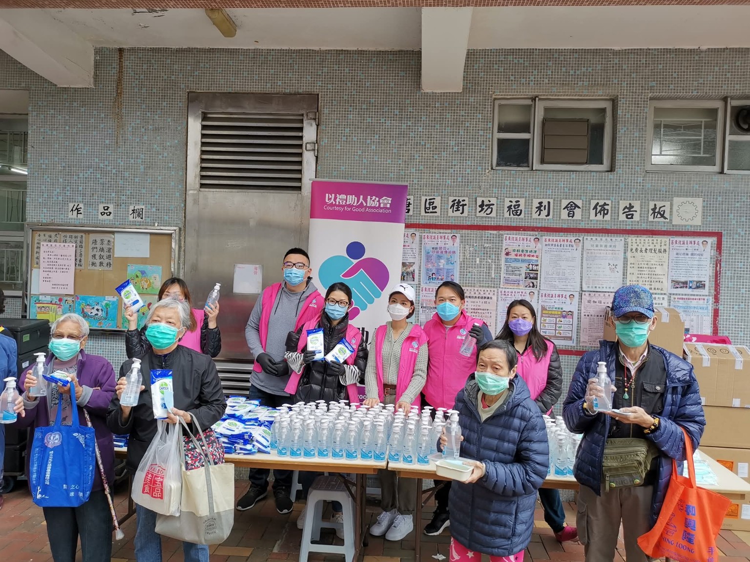 義工與長者在社區活動中展示酒精搓手液及消毒濕紙巾。